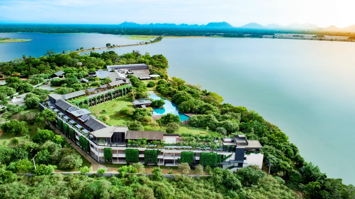 An aerial view of a lakeside resort surrounded by lush greenery